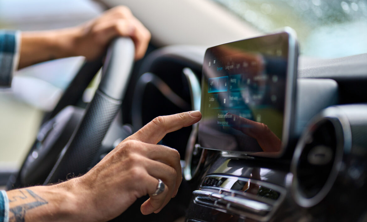 Man traveler sitting in car using gps navigation on monitor while driving.