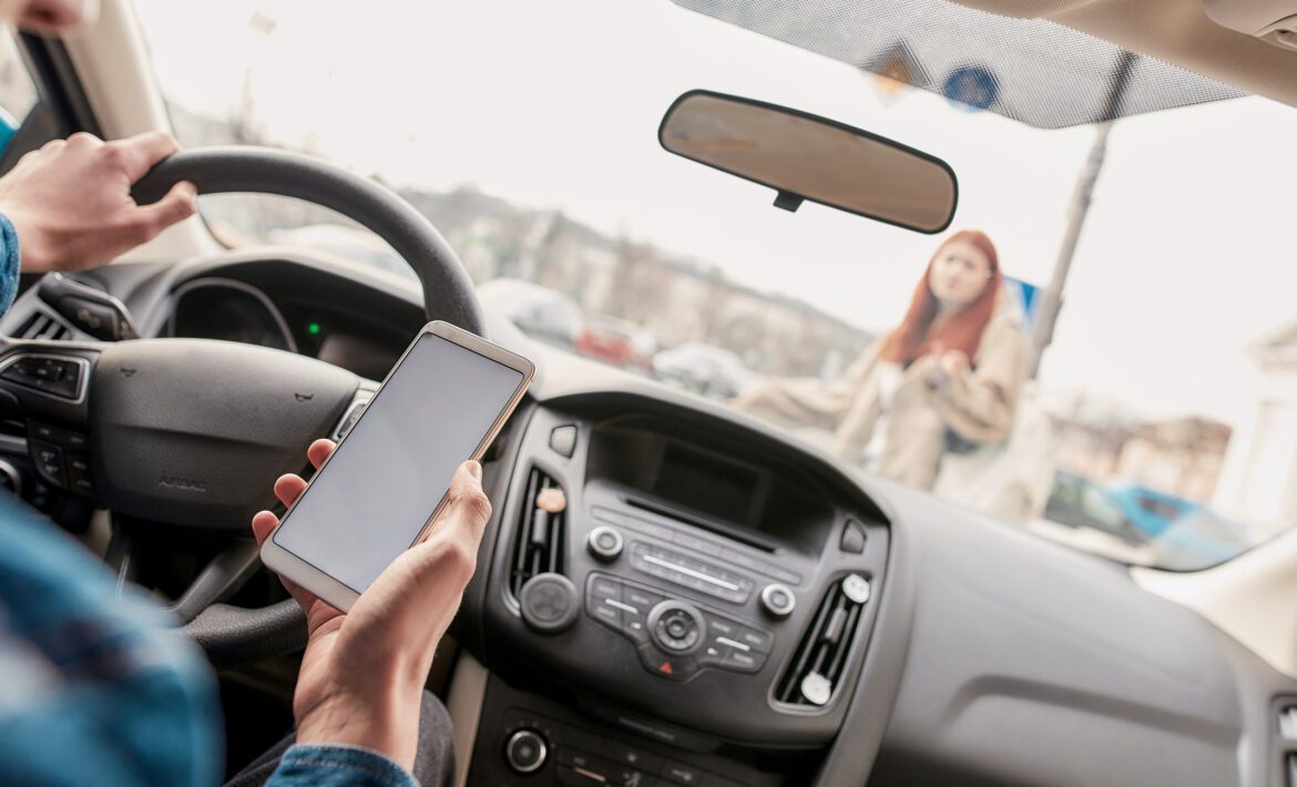 Distracted young male driver using his mobile phone